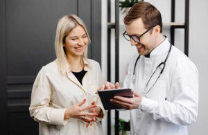 Clinical researcher discusses digital reconsent with a trial participant using a tablet during a clinical trial visit